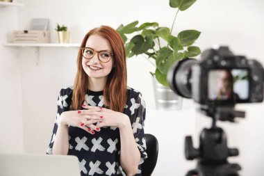 Neşeli genç blogger evde dijital kamera video çekimi