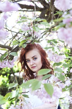 Genç Bayan bahar çiçek açan bahçede yürüyüş