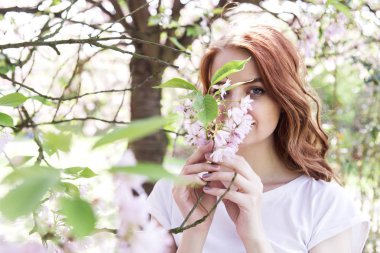 Genç Bayan bahar çiçek açan bahçede yürüyüş