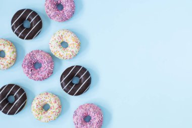 Pastel mavi zemin üzerine sırlı donuts topluluğu