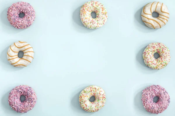 Pastel mavi zemin üzerine sırlı donuts topluluğu