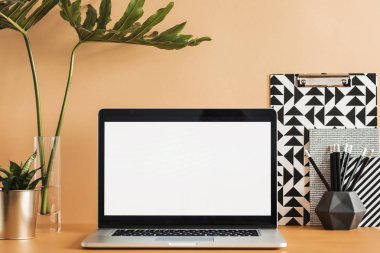 Minimalist çalışma alanı boş dizüstü ekran, ileti örneği ve yeşil bitkiler ile