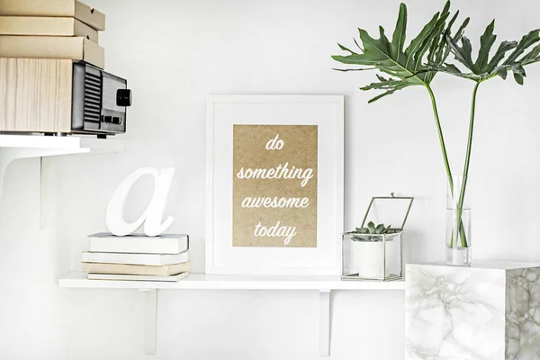 Bright white interior corner with shelves and inspirational phrase in frame on wall