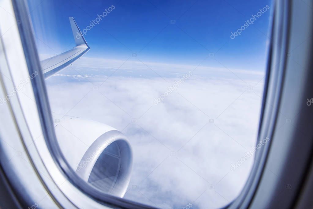 Flying above clouds, view from airplane porthole