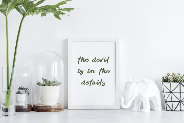Modern white workplace with elephant figure and frame on white background