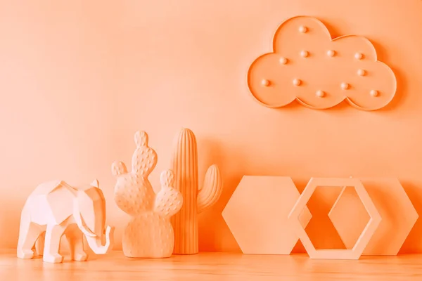 The design orange desk with cacti, elephant, hexagon shapes and cloud. Modern mock up concept. Orange is the new black.