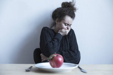 Üzgün kadın Kırmızı elma ile plaka üzerinde seyir 