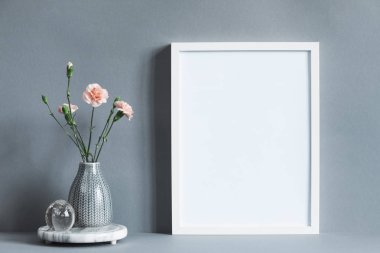 boş çerçeve gri arka plan üzerinde vazoda taze karanfil buketi ile