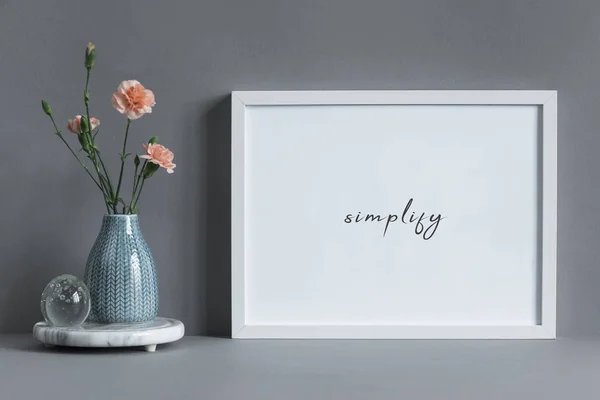 Minimalistic frame with inspirational phrase and carnations in vase