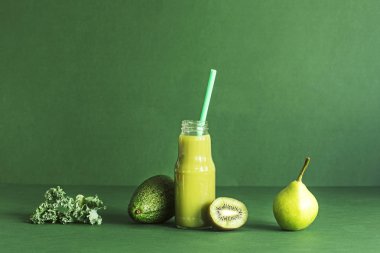 Kivi, avokado, şeftali ve salata ile taze ev yapımı güler yüzlü yeşil arka plan üzerinde bırakır