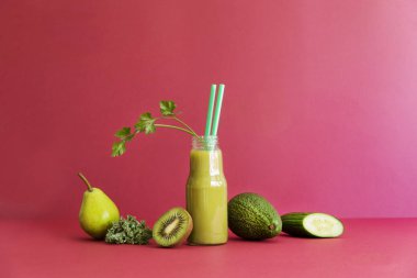 Şeftali, avokado, kivi, salata yaprağı ve salatalığın üzerinde pembe bir arka plan ile taze ev yapımı güler yüzlü