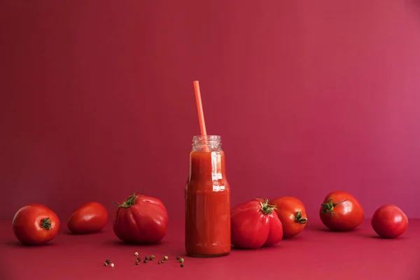 自制番茄冰沙与新鲜的西红柿在红色背景 — 图库照片
