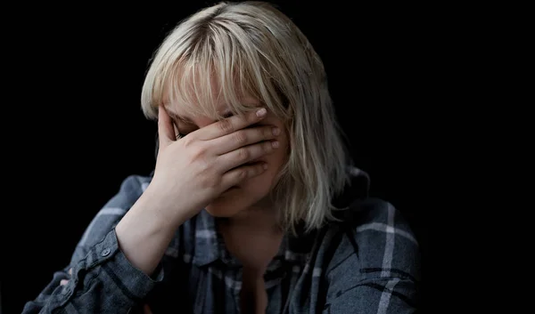 Portrait of sad depressed young woman on black background