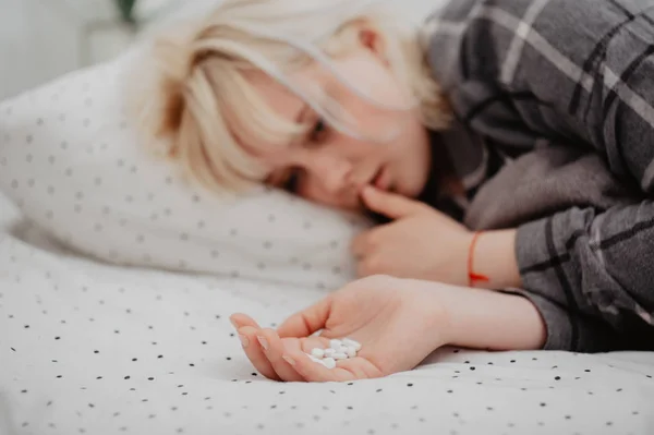 Depressive Junge Frau Liegt Bett Und Hält Handfläche Voller Tabletten — Stockfoto