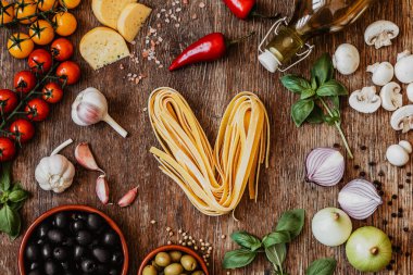 Ahşap arka plan üzerinde geleneksel İtalyan makarna için malzemeler topluluğu 