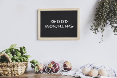 Dize-çanta, yumurta ve ahşap mutfak masasında yeşil yaprakları kırmızı elmalar