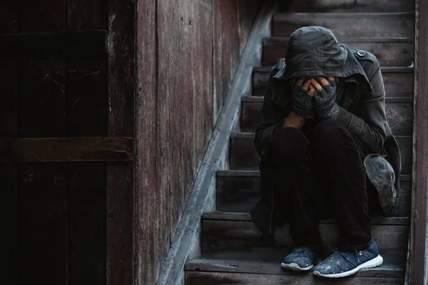 无家可归的人坐在旧楼的楼梯上 他暖和了 现代大城市的问题 — 图库照片