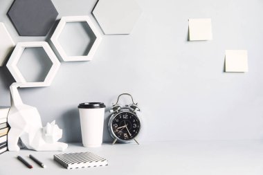 Gri modern ve şık çalışma alanı withhexagone şekiller, dizüstü bilgisayarlar, not çubukları, kedi figürü ve ofis aksesuarları. Masanın yaratıcı kompostiyasyonu.