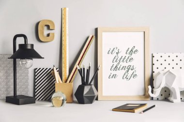 Sahte kadar poster çerçevesi, seramik şekil, açık gri renkli bitkiler ile yaratıcı dolap