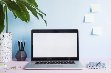 Dizüstü bilgisayar ekranı ve ofis aksesuarları pastel mavi zemin üzerine kadar sahte ile modern çalışma alanı 