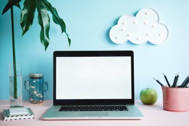 Dizüstü bilgisayar ekranı ve ofis aksesuarları pastel mavi zemin üzerine kadar sahte ile modern çalışma alanı 