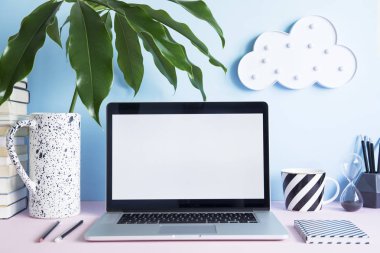 Dizüstü bilgisayar ekranı ve ofis aksesuarları pastel mavi zemin üzerine kadar sahte ile modern çalışma alanı 