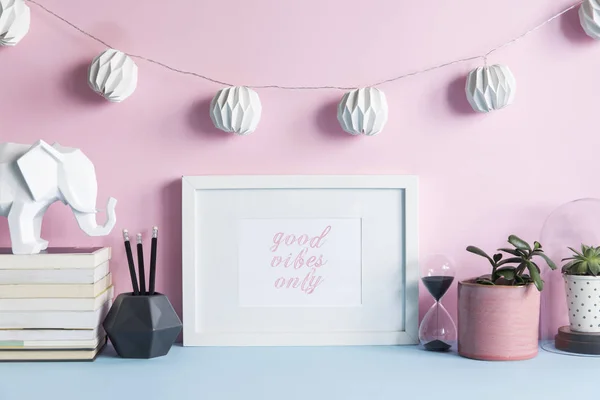 Creative cupboard with mock up poster frame, ceramic figure, plants on pastel pink background