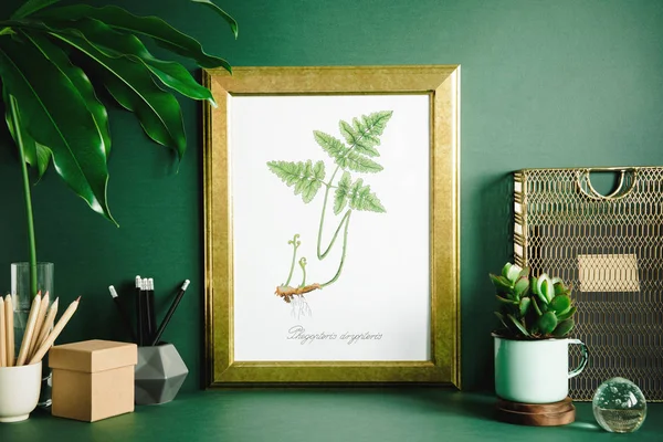 Creative cupboard with mock up poster frame, ceramic figure, plants on green background