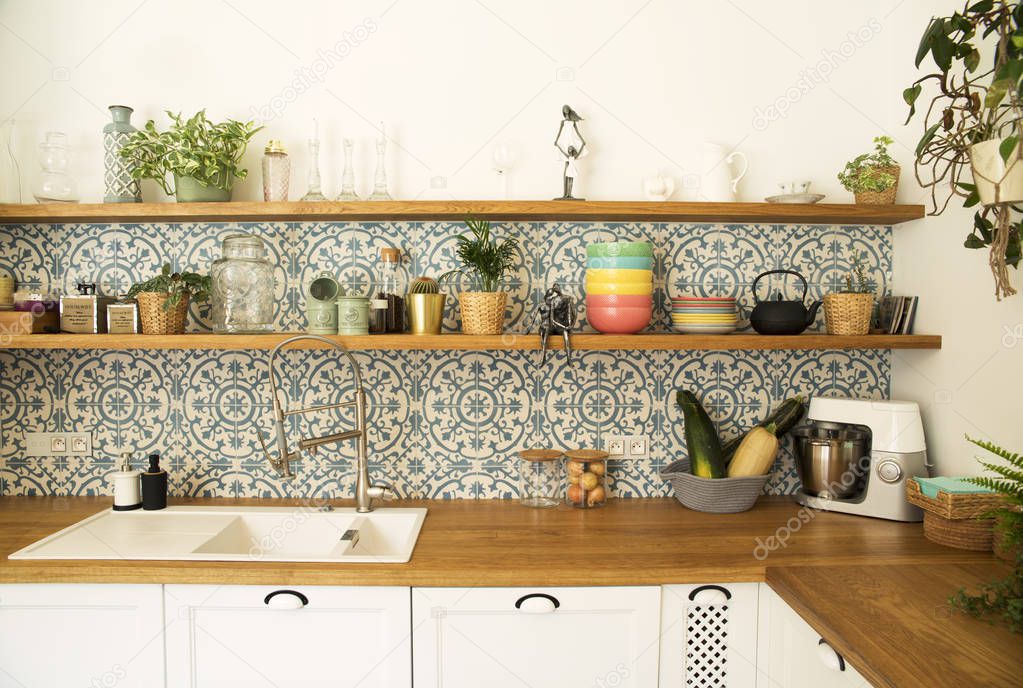 Fresh summer breakfast in Mediterranean style kitchen. Bright and sunny space with a lot of herbs and plants.