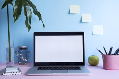 Dizüstü bilgisayar ekranı ve ofis aksesuarları pastel mavi zemin üzerine kadar sahte ile modern çalışma alanı 