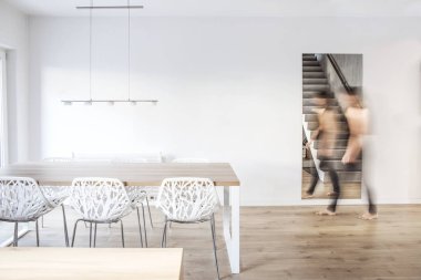 Ahşap masa ve sıra dışı beyaz sandalyeler ile modern yemek odası