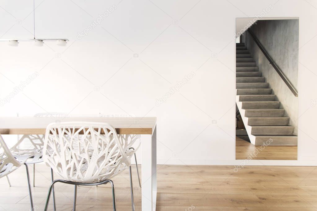 Modern dining room with wooden table and unusual white chairs