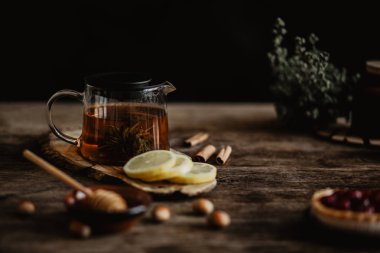 Ahşap arka plan krizantem çay ve limon dilimleri ile cam çaydanlık