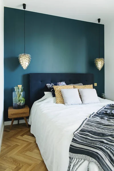 Stylish bedroom in dark blue and golden colors