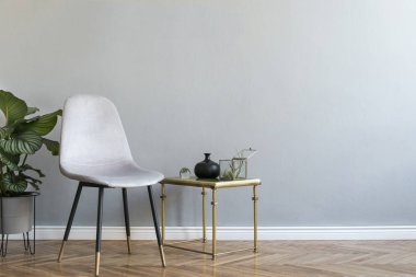 Gri kadife sandalye ile lüks ve minimalist gri ev iç, siyah standı nda aksesuarları ve tropikal bitki ile masa. Yazıt için yer kopyala, posteri taklit et. Boş duvar.