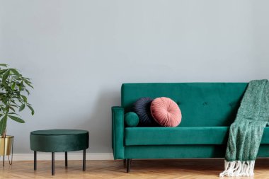 Yeşil kadife tasarım kanepe ve puf, tropikal bitki ve zarif battaniye ve yastıklar ile minimalist ev iç. Yazıt için yer kopyala, posteri taklit et. Kahverengi ahşap parke.
