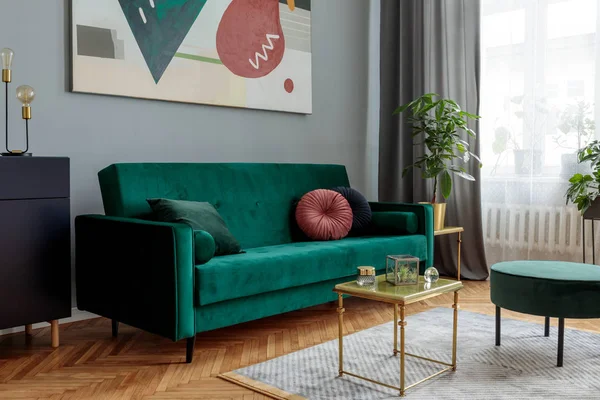 豪华时尚的内饰 配有绿色天鹅绒设计沙发 咖啡桌 Pouf Commode 灰色墙壁与抽象绘画 客厅的时尚装饰 棕色木制镶木地板 — 图库照片