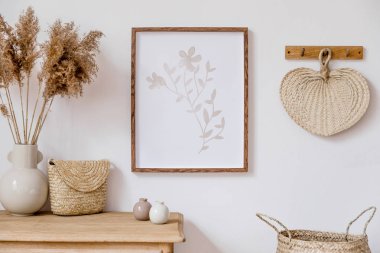 Kahverengi sahte poster çerçevesi, zarif aksesuarlar, vazo çiçekler, ahşap raf ve asılı Rattan yaprak ile oturma odası şık Koreli iç. Ev dekoru Minimalistic kavramı. Şablon. 