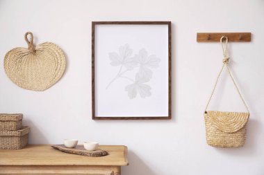 Kahverengi sahte poster çerçevesi, zarif aksesuarlar, kutular, ahşap raf ve asılı Rattan çanta yaprak ile oturma odası şık Koreli iç. Ev dekoru Minimalistic kavramı. Şablon. Aydınlık Oda.
