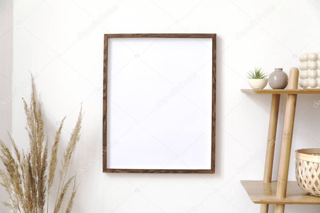 Stylish korean interior of living room with brown mock up poster frame, elegant accessories, leafs, wooden shelf and rattan basket. Minimalistic concept of home decor. Template. 