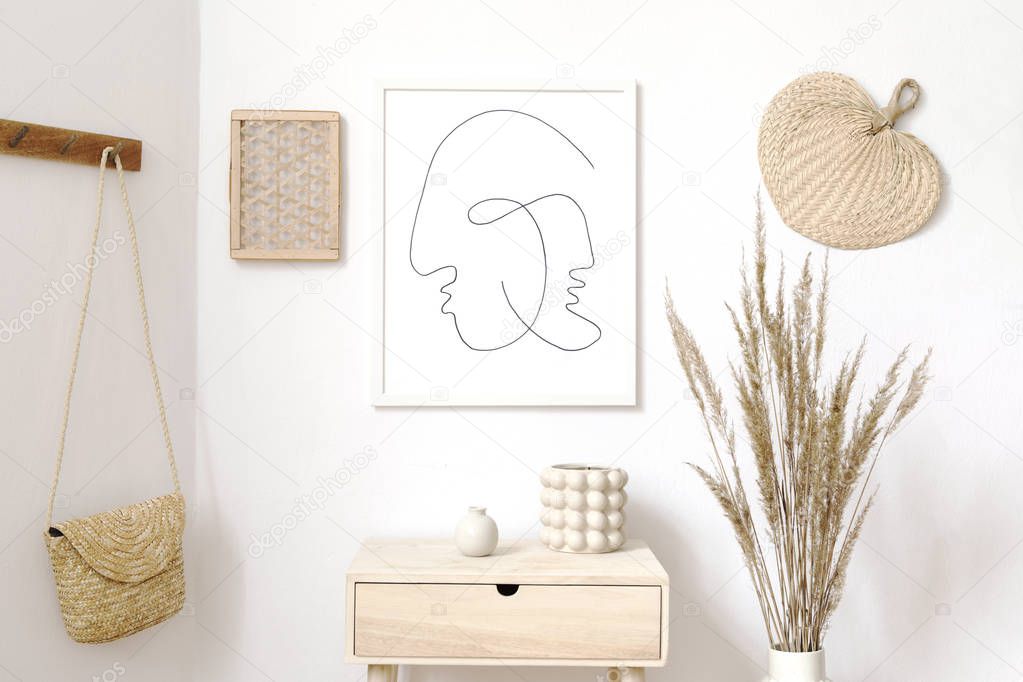 Stylish white interior of living room with mock up poster frame, rattan accessories, leaf, wooden shelf, vase with flowers and elegant personal stuff. Minimalistic concept of home decor. Template. 