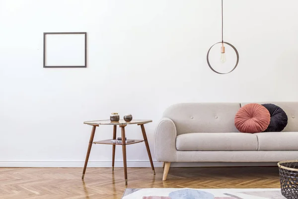 Stylish minimalistic living room with design grey sofa, geometric lamp, coffee table, pillows and elegant accessories Mock up posters frame on the white walls. Minimalistic home decor.