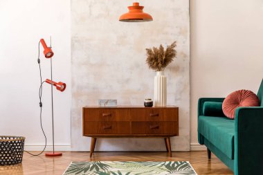 Vintage dolap, kadife kanepe, vazo çiçekler, tasarım turuncu lambalar, zarif aksesuarlar ve soyut resimler ile retro ev iç şık compositon. Minimalist kavram. Güzel ev dekorasyonu. 