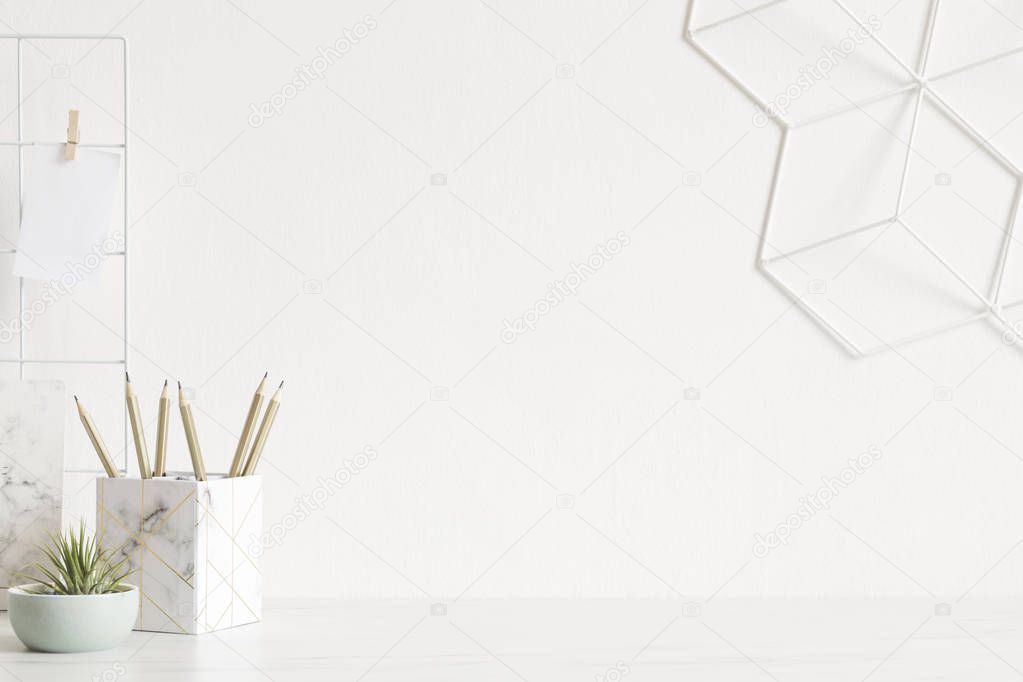 White and stylish home interior with cool office accessories, notebooks, marble box geometric organizer and air plants. Scandinavian home decor. Minimalistic concept. Template. Copy space.