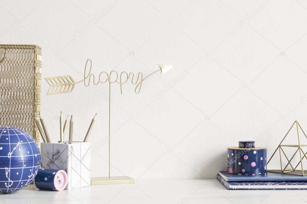 Cosmic and stylish home interior with cool office accessories, tapes, supplies, notebooks, memo sticks, pencils. Gold happy sign. Design home decor. Minimalistic concept. Template. Copy spce.