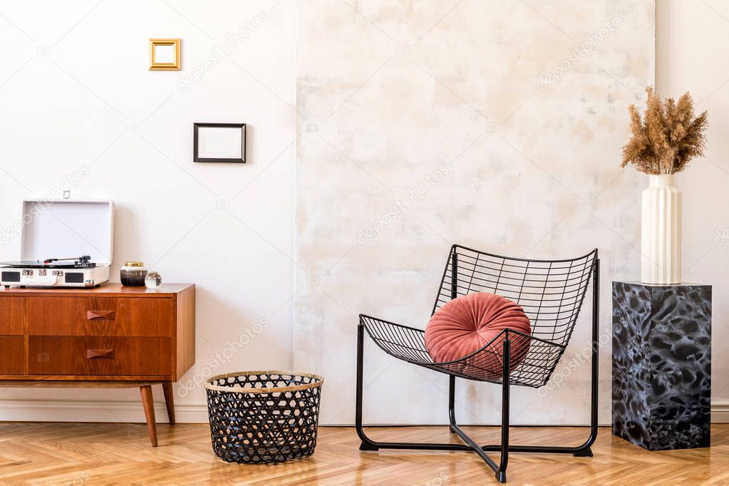 Stylish compositon of retro home interior with mock up phot frames, vintage cupboard,white gramophone, marble stand, design armchair and abstract paintings. Minimalistic concept. Nice home decor. 