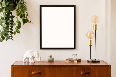 Retro mobilyalar, asma tesisi, altın masa lambası ve zarif aksesuarlar ile minimalist ve şık poster çerçeve konsepti ile alay. Beyaz duvarlar, ev dekorasyonu. Oturma odasının güzel iç. Gerçek fotoğraf.