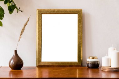 Altın poster çerçevesi, zarif aksesuarları, vazo, mum lar ve kutu çiçekleri ile vintage dolap kadar sahte ile ev iç minimalist ve retro alan. Şık ev dekorasyonu. Beyaz duvarlar. Şablon.