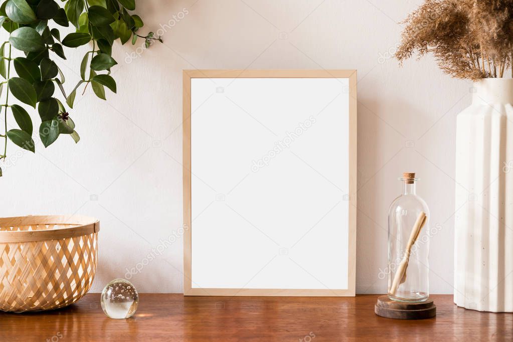 Stylish and retro space of home interior with mock up poster frame, vintage cupboard with retro accessories, flowers in vase, plants and letter in bottle . Nice home decor. Minimalistic concept. 