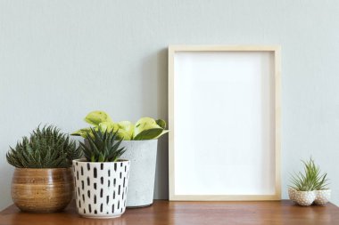 Tasarım retro tablo ile şık İskandinav iç, fotoğraf çerçevesi ve tasarım tencere ve aksesuarları güzel bitkiler kadar beyaz mock. Modern ev dekorasyonu. Gri arka plan duvarı. Minimalist kavram.